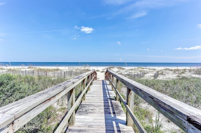 surrounding community featuring a water view and a beach view