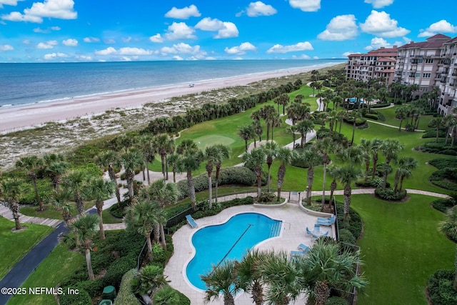 pool featuring a patio area, a water view, and a view of the beach