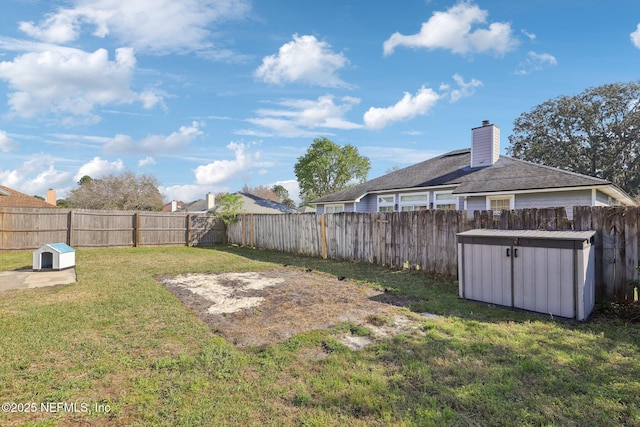 view of yard with an outbuilding, a shed, and a fenced backyard