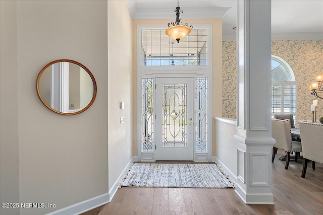 entrance foyer featuring ornamental molding, wallpapered walls, baseboards, and hardwood / wood-style flooring