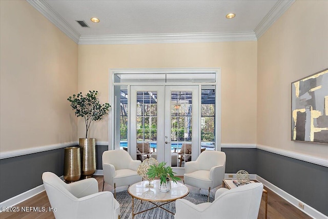 sitting room featuring ornamental molding, french doors, visible vents, and wood finished floors