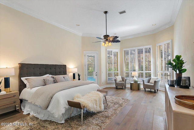 bedroom with light wood-style floors, access to outside, visible vents, and ornamental molding