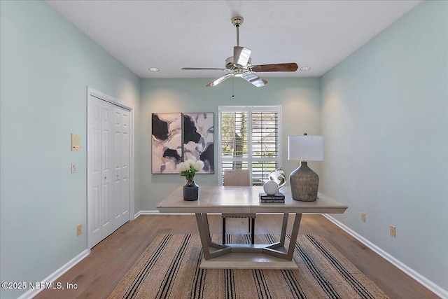 office space featuring ceiling fan, baseboards, and wood finished floors