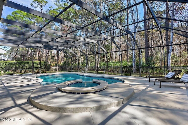 view of swimming pool with a patio area, a pool with connected hot tub, and glass enclosure