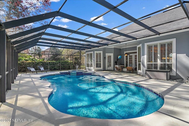 view of pool featuring glass enclosure, ceiling fan, and a patio