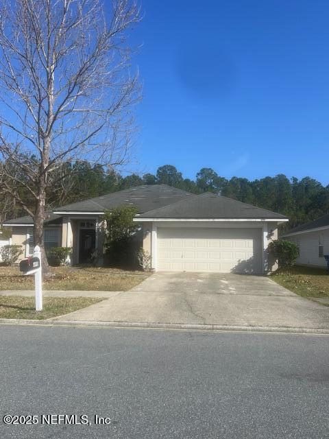 view of front of house with driveway, an attached garage, and stucco siding