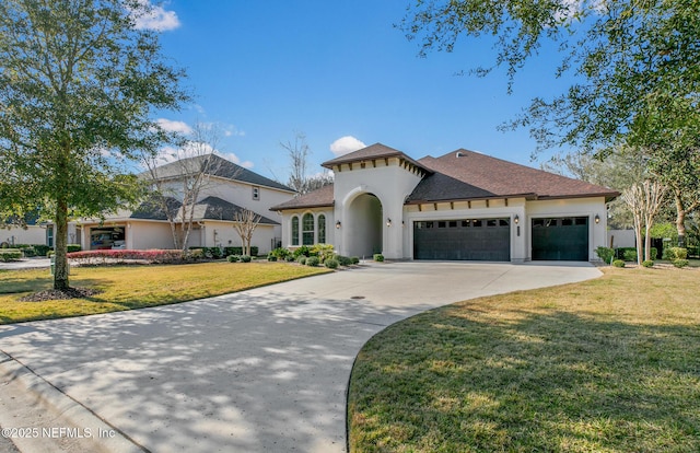 mediterranean / spanish-style home featuring a garage, driveway, a front yard, and stucco siding