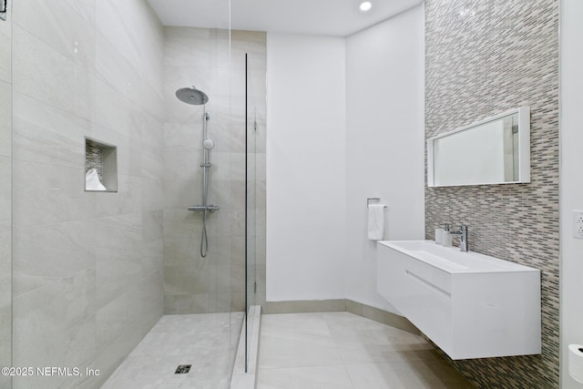 bathroom featuring a tile shower, vanity, and tile patterned floors