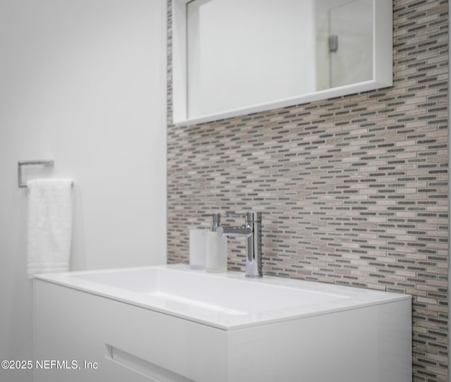 bathroom with vanity and decorative backsplash