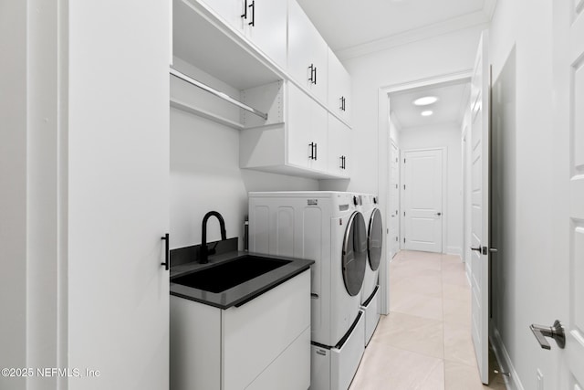 washroom with washer and clothes dryer, cabinet space, ornamental molding, light tile patterned flooring, and a sink