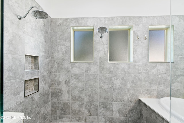 full bath with a relaxing tiled tub and a tile shower