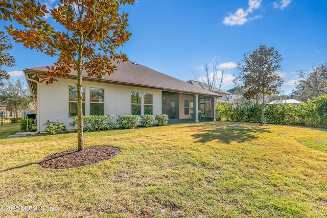 rear view of house with a yard, a shingled roof, fence, and a sunroom