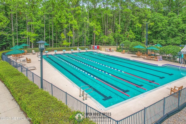 community pool featuring a patio area and fence