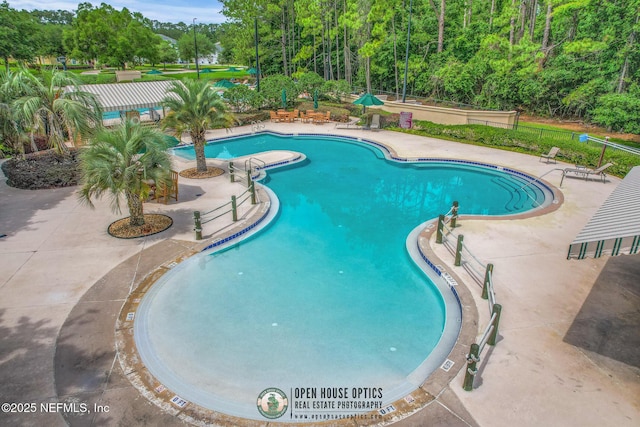 pool with a patio and fence