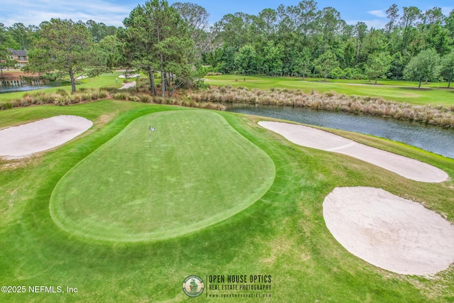 surrounding community featuring a water view, view of golf course, and a yard