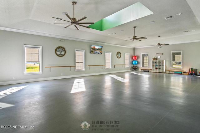 interior space featuring a raised ceiling, visible vents, a ceiling fan, a textured ceiling, and baseboards