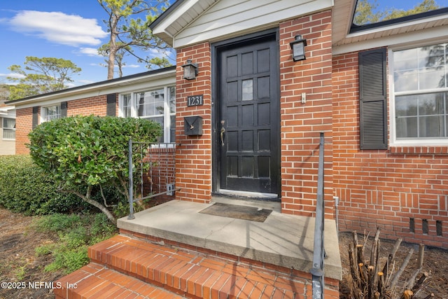 view of exterior entry with brick siding