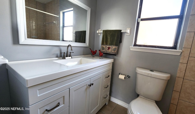 bathroom featuring tile patterned flooring, vanity, toilet, and baseboards