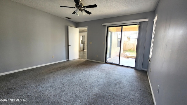 unfurnished room featuring baseboards, visible vents, dark carpet, and a textured ceiling