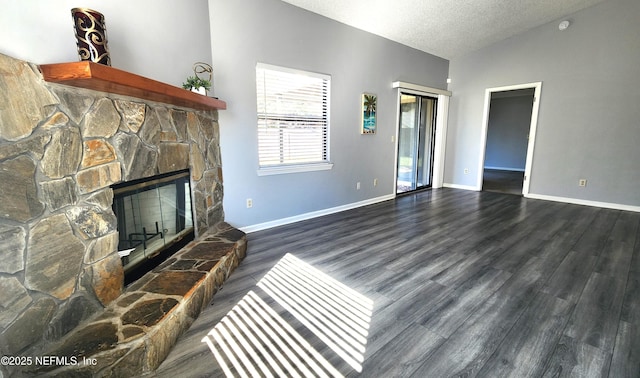 living room featuring a textured ceiling, dark wood-type flooring, a fireplace, baseboards, and vaulted ceiling