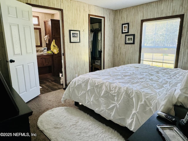 bedroom featuring carpet, connected bathroom, a walk in closet, and a closet