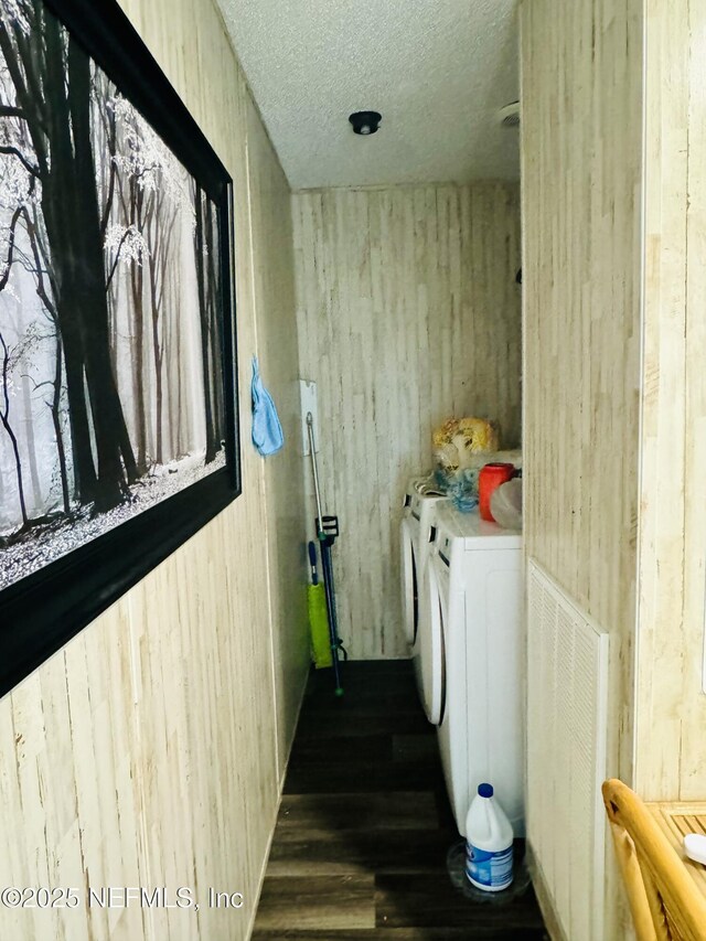 laundry area with dark wood finished floors, radiator heating unit, washing machine and dryer, a textured ceiling, and laundry area