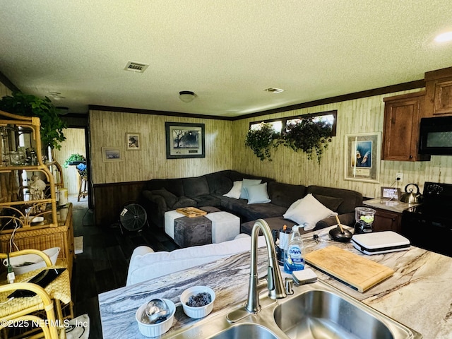 living room with visible vents, a textured ceiling, and wood finished floors