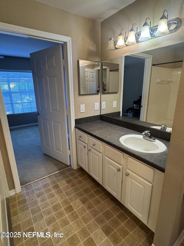 bathroom featuring a textured ceiling and vanity