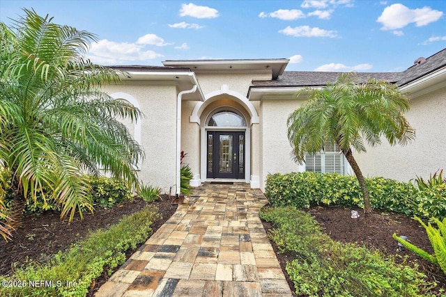 view of exterior entry with stucco siding