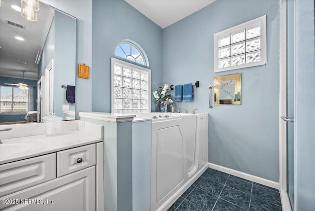 ensuite bathroom with tile patterned flooring, vanity, visible vents, baseboards, and a bath