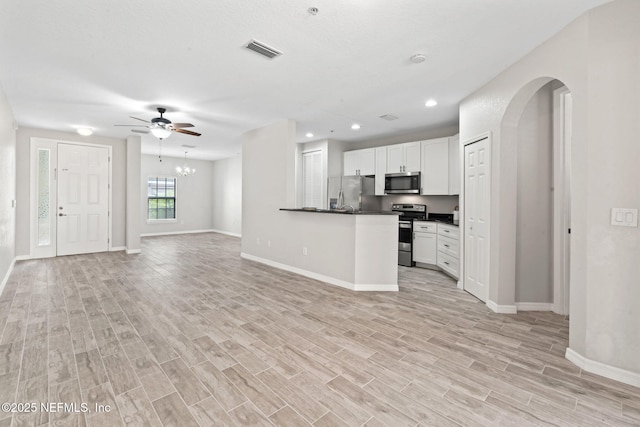 kitchen with visible vents, open floor plan, appliances with stainless steel finishes, light wood finished floors, and dark countertops