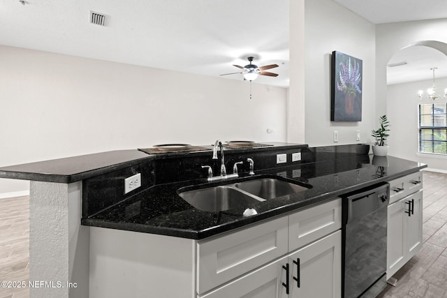 kitchen with arched walkways, black dishwasher, visible vents, a sink, and light wood-type flooring