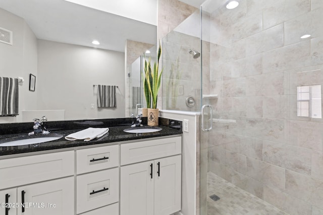 bathroom with a stall shower, a sink, recessed lighting, and double vanity