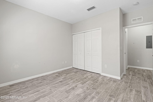 unfurnished bedroom featuring light wood finished floors, electric panel, and visible vents