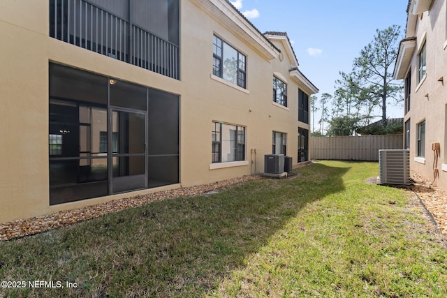 view of yard with central AC and fence