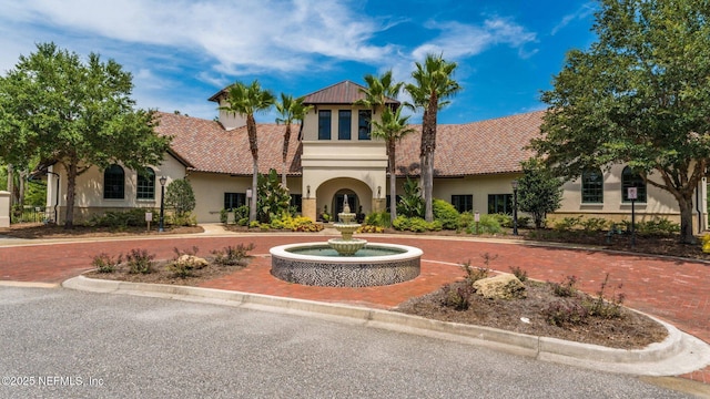 mediterranean / spanish house with a tiled roof and stucco siding