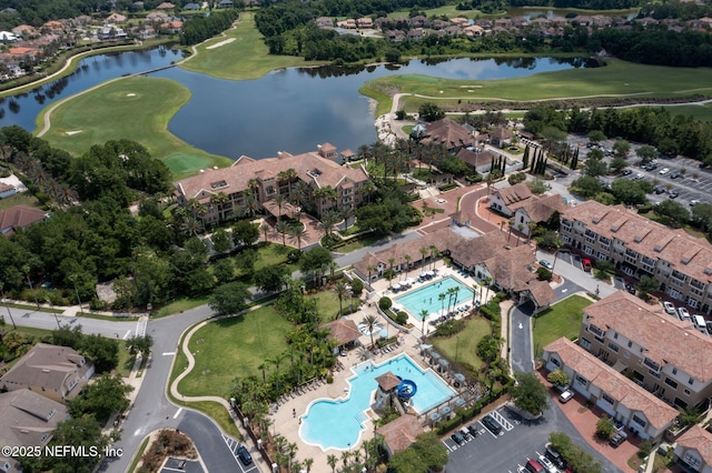 drone / aerial view featuring golf course view and a water view