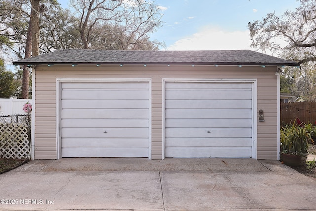 detached garage featuring fence