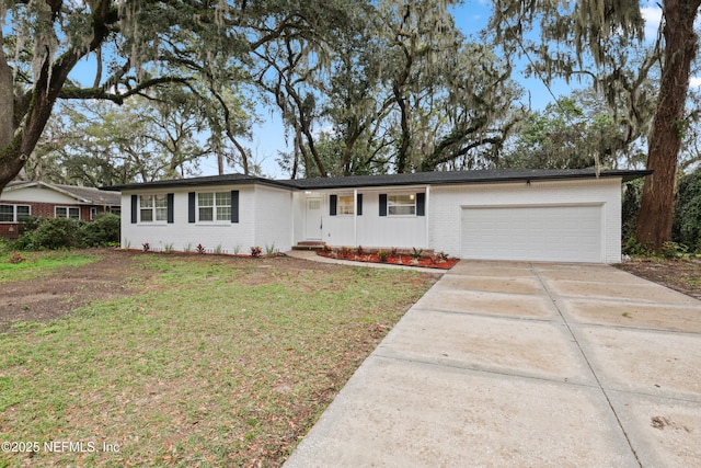 single story home featuring a garage, brick siding, driveway, and a front lawn