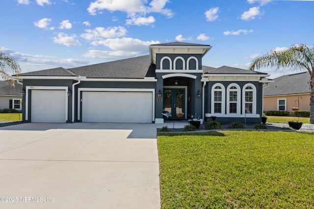 986 Prairie Dunes Ct, Orange Park, FL 32065 - mediterranean / spanish-style home featuring stucco siding, an attached garage, driveway, a front lawn, and a shingled roof