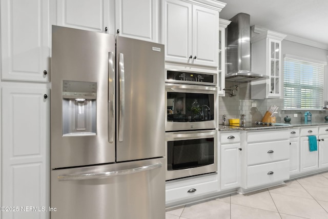 986 Prairie Dunes Ct, Orange Park, FL 32065 - kitchen featuring light tile patterned flooring, wall chimney exhaust hood, tasteful backsplash, appliances with stainless steel finishes, and glass insert cabinets