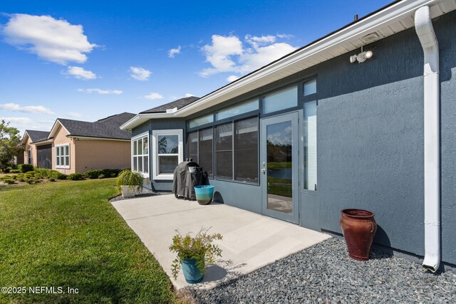 986 Prairie Dunes Ct, Orange Park, FL 32065 - back of property featuring a lawn, stucco siding, and a patio area