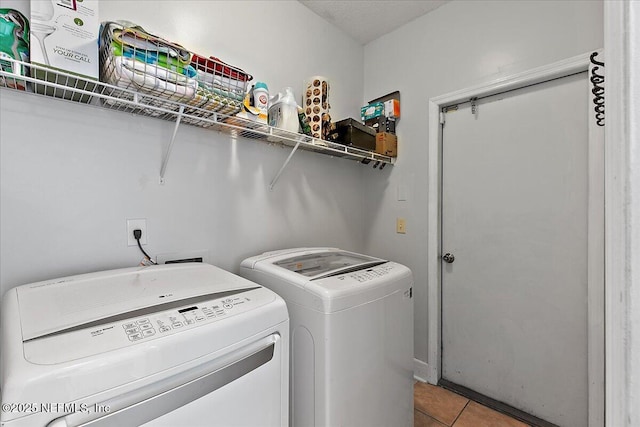 laundry room with laundry area, separate washer and dryer, and light tile patterned flooring