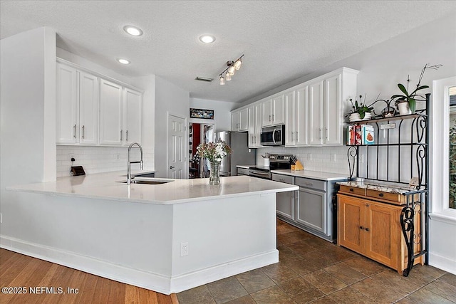 kitchen featuring appliances with stainless steel finishes, white cabinets, and light countertops