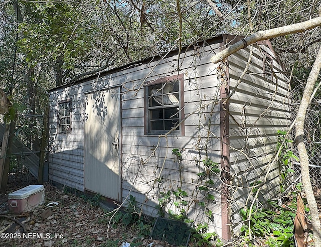 view of property exterior featuring fence and an outdoor structure