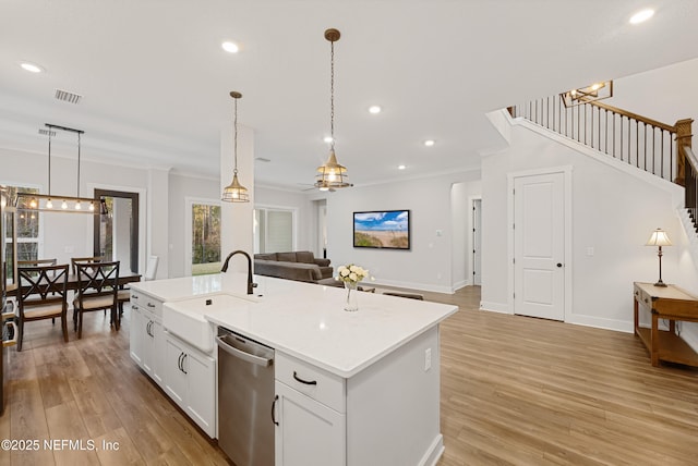 kitchen with visible vents, open floor plan, light countertops, dishwasher, and an island with sink