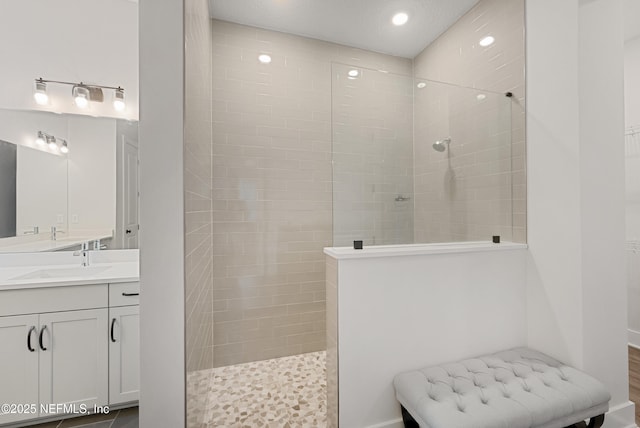 full bath with recessed lighting, vanity, and a walk in shower