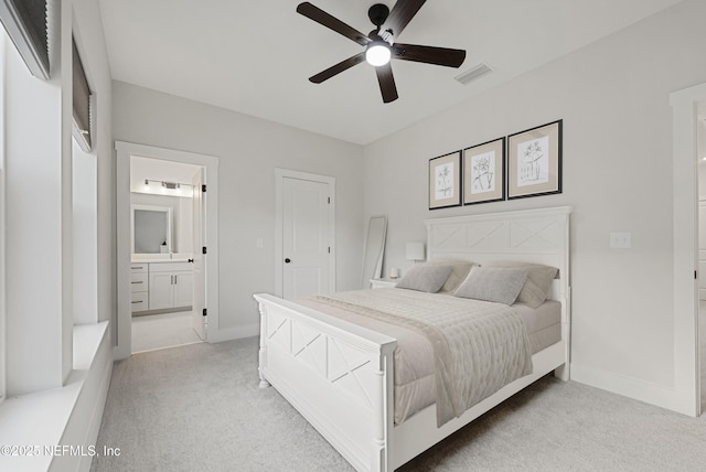 bedroom featuring ensuite bath, visible vents, baseboards, and light colored carpet