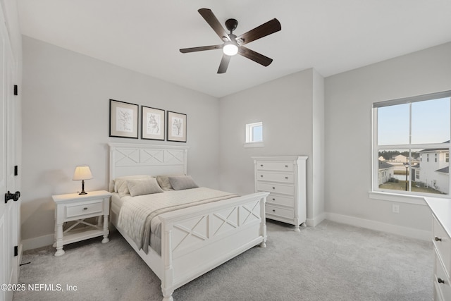 bedroom with light colored carpet, multiple windows, and baseboards