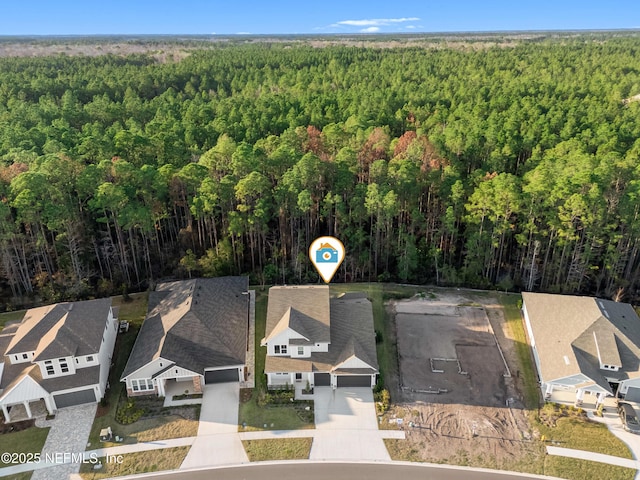 birds eye view of property featuring a forest view and a residential view